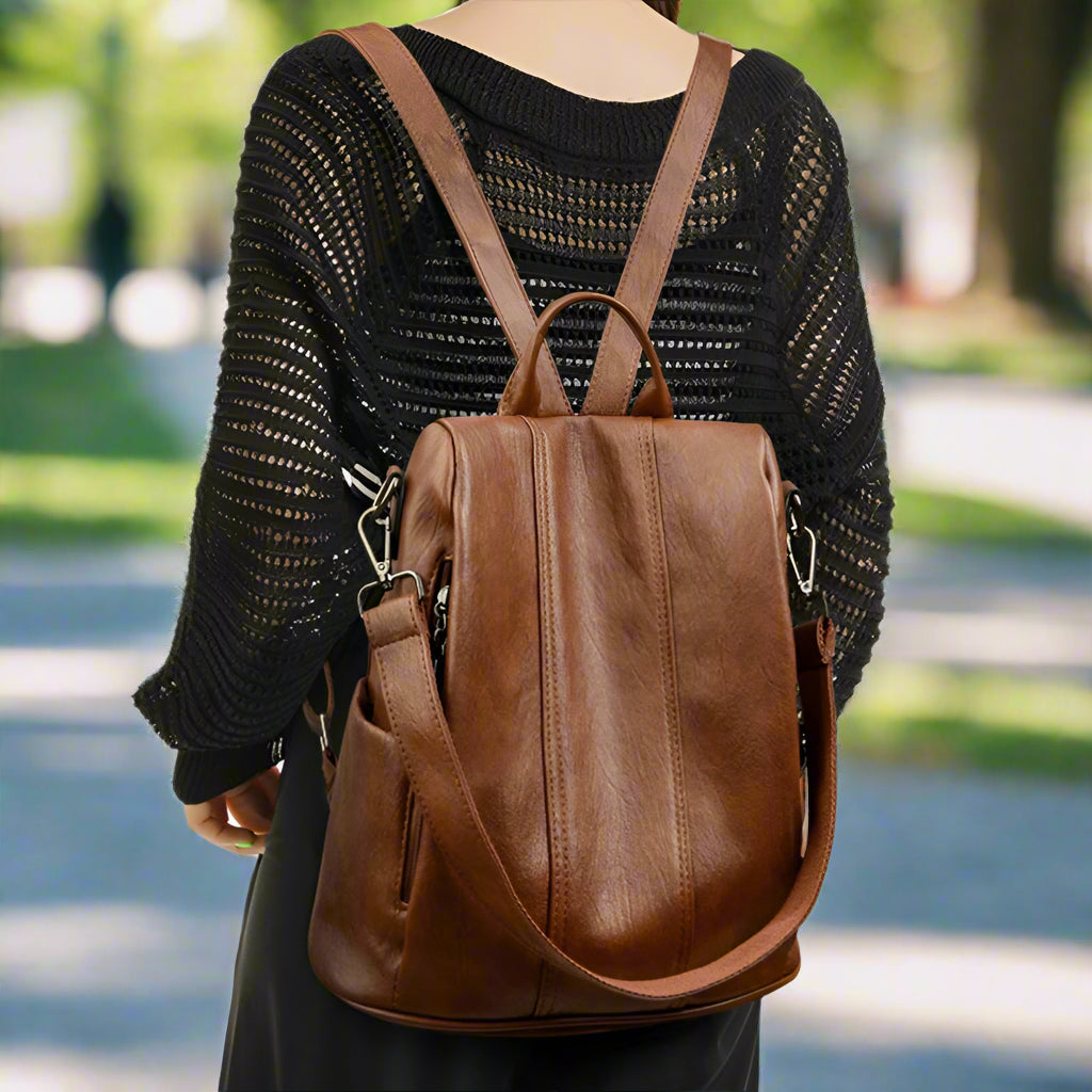 Woman wearing a brown vegan leather backpack on a white background